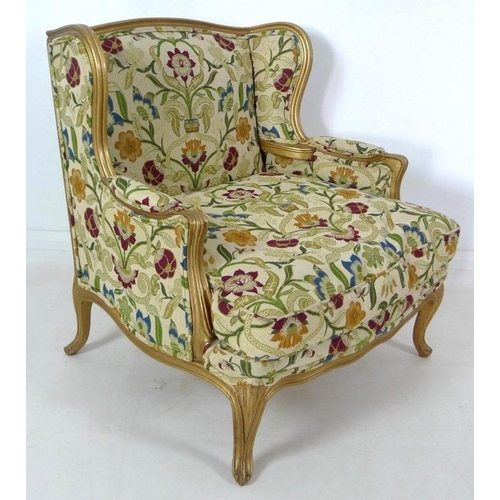 889 - A French carved wood wing armchair, in 19th century style, with gold coloured painted frame,  cream ... 