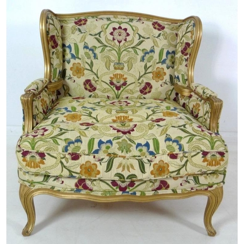 889 - A French carved wood wing armchair, in 19th century style, with gold coloured painted frame,  cream ... 