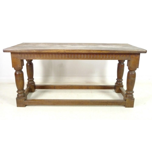 889A - An oak refectory table, three plank surface over a chip carved frieze, supported on heavy baluster t... 