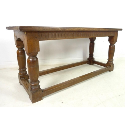 889A - An oak refectory table, three plank surface over a chip carved frieze, supported on heavy baluster t... 