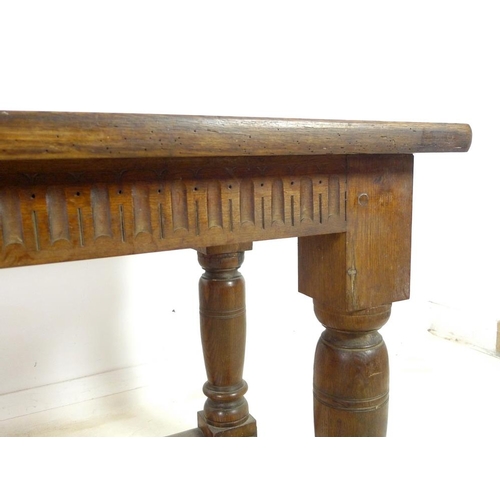 889A - An oak refectory table, three plank surface over a chip carved frieze, supported on heavy baluster t... 