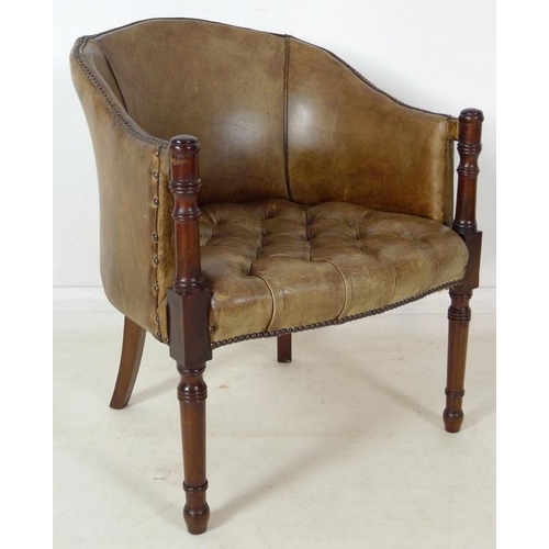 890 - A Georgian style green/beige leather library armchair, with buttoned seat and brass tacks, turned fr... 