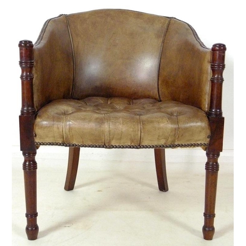 890 - A Georgian style green/beige leather library armchair, with buttoned seat and brass tacks, turned fr... 