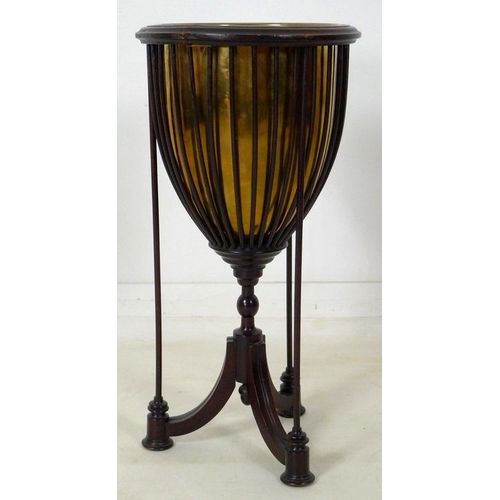 899 - An Edwardian mahogany plant stand, with spindle cage holding a brass lining, raised on three splay f... 