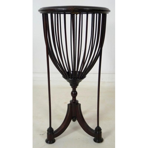 899 - An Edwardian mahogany plant stand, with spindle cage holding a brass lining, raised on three splay f... 