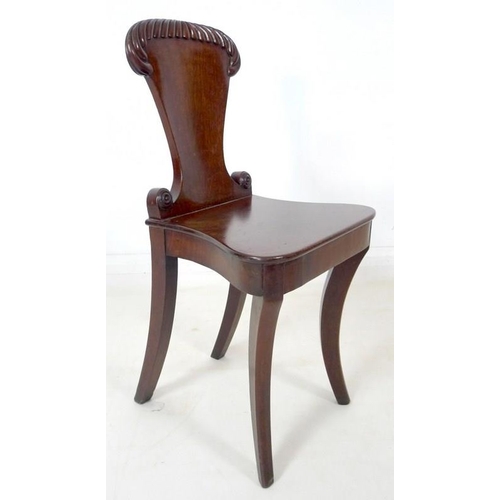 907 - A Regency mahogany hall chair, circa 1820, with gadrooned carving to the shield shaped back, raised ... 