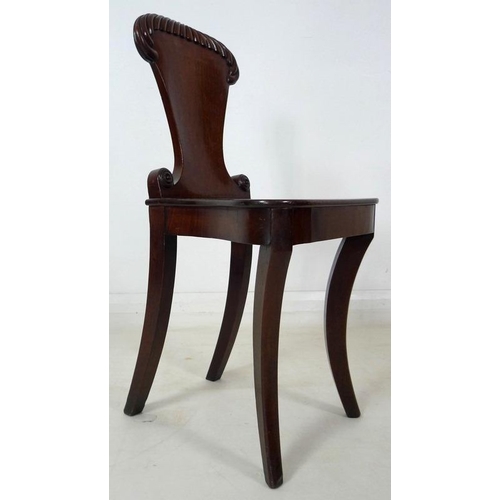 907 - A Regency mahogany hall chair, circa 1820, with gadrooned carving to the shield shaped back, raised ... 