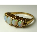 An Edwardian opal ring, the five graduated oval stones claw set in a pierced yellow metal band, size... 