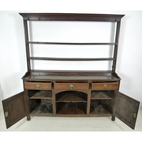 1001 - A Georgian oak and inlaid dresser, two shelf plate rack, the base with three frieze drawers, cast br... 