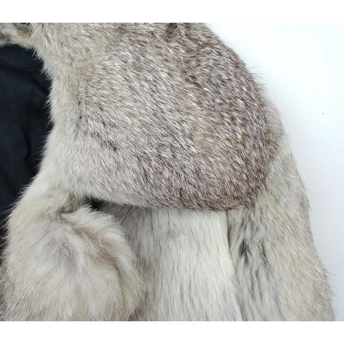 716 - Two fur coats, one a grey Angora example with belt, the other a black fur longcoat. (2)