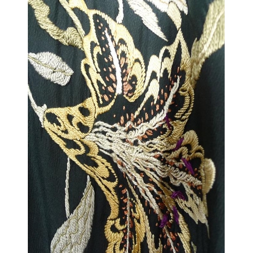 722 - An early 20th century kimono dressing gown, the black silk embroidered with flowers and foliage, wei... 