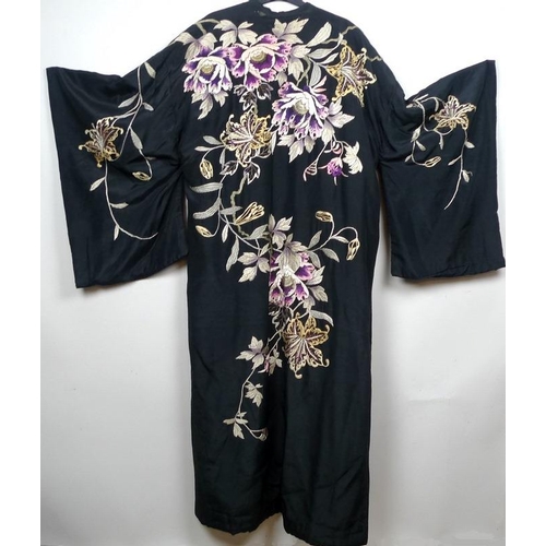 722 - An early 20th century kimono dressing gown, the black silk embroidered with flowers and foliage, wei... 