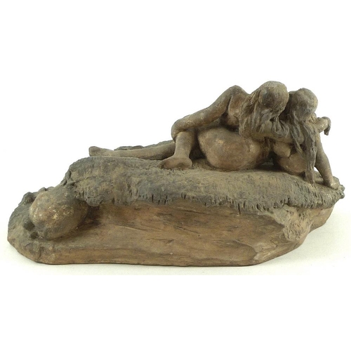 754 - A mid 20th century clay sculpture of two female lovers lying in a Sapphic pose on a roughly woven bl... 