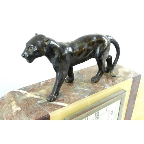 767 - A French Art Deco clock garniture, the clock with hollow cast patinated bronze lioness surmount abov... 