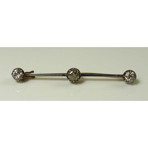 843 - A three stone diamond bar brooch, the central diamond of approximately 0.6ct, 5.5 by 5.4 by 3.4mm, f... 