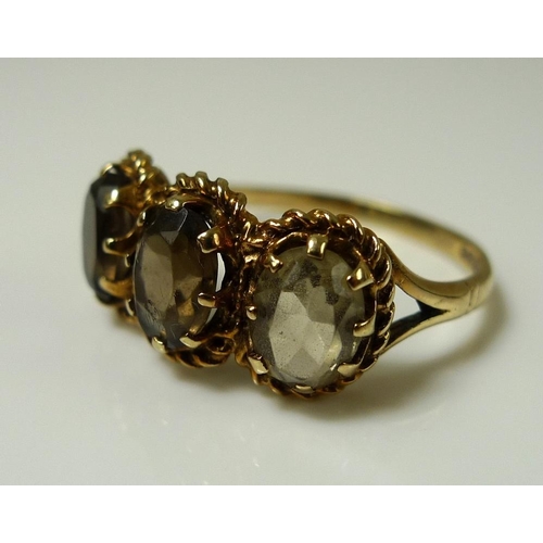 865 - A 9ct gold and yellow topaz ring, the three oval stones each 7.7 by 5.2 by 3.3mm and mounted in a ro... 