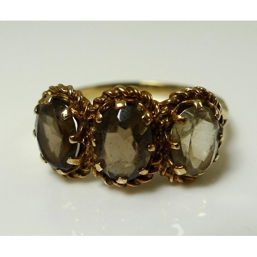 865 - A 9ct gold and yellow topaz ring, the three oval stones each 7.7 by 5.2 by 3.3mm and mounted in a ro... 