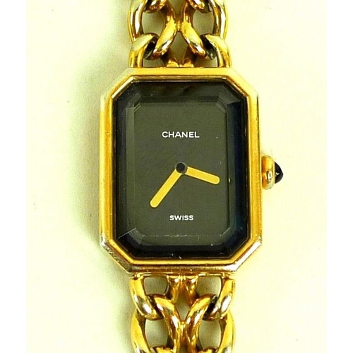 884 - A lady's gold plated Chanel watch, circa 1990, with black rectangular face with canted corners, gold... 