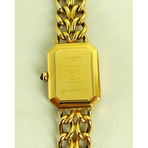 884 - A lady's gold plated Chanel watch, circa 1990, with black rectangular face with canted corners, gold... 