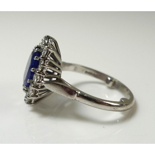 900 - An 18ct white gold, sapphire and diamond ring, the large dark cornflower blue oval sapphire 8mm by 7... 