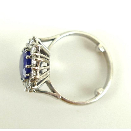 900 - An 18ct white gold, sapphire and diamond ring, the large dark cornflower blue oval sapphire 8mm by 7... 