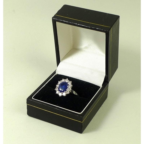 900 - An 18ct white gold, sapphire and diamond ring, the large dark cornflower blue oval sapphire 8mm by 7... 