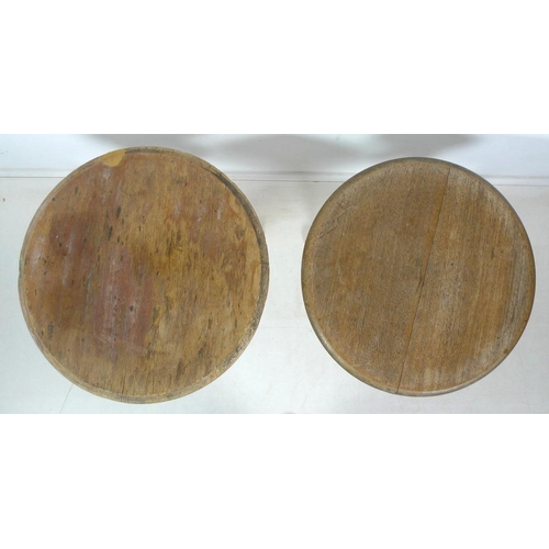 905 - A near pair of late 19th or early 20th century tables, circular oak tops above cast tri-legged suppo... 