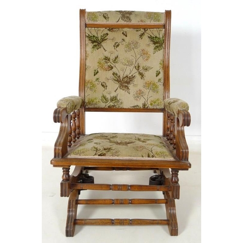 911 - A mid 20th century oak framed rocking chair, sprung rocking base, turned spindles to padded arms, up... 