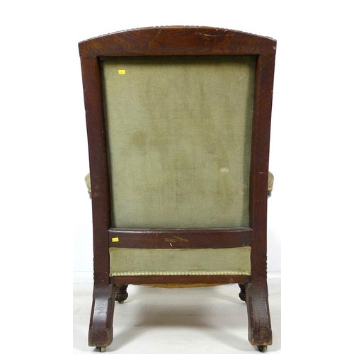 930A - A Victorian oak framed library armchair, circa 1880, with squared back, the padded armrest with turn... 