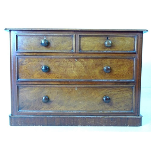 932 - An early Victorian mahogany chest of two over two drawers, with turned handles, raised on plinth bas... 