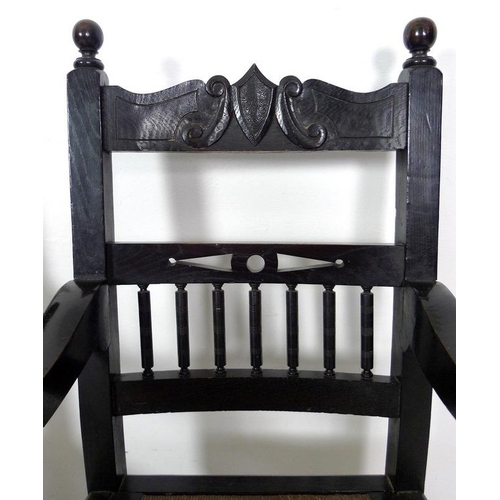 935 - A late 19th century stained oak open armchair, carved crest to the top rail , drop in rush seats, ri... 