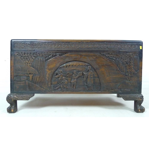 937 - A 20th century carved Chinese camphor wood chest, the body carved with panels depicting figures amid... 