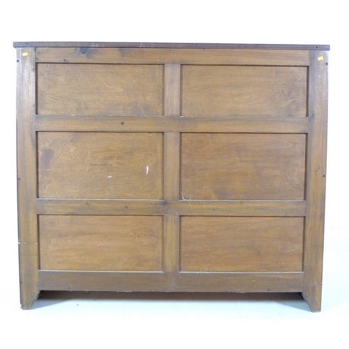 941 - A mid 20th century stained oak bookcase, with two full width slide and hide leaded glass doors, over... 