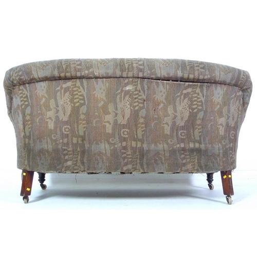 955 - An Edwardian two seater settee, carved back, sprung seat and turned front legs with later castors, u... 