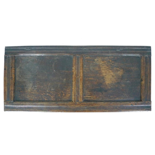 986 - An early 18th century oak coffer, three panel front with a carved frieze of leaves, lift lid with ca... 