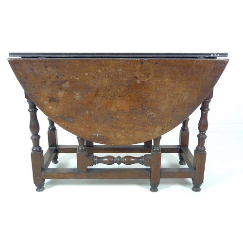 994 - An 18th century oak drop leaf table, oval surface, single drawer with brass knob, turned supports wi... 