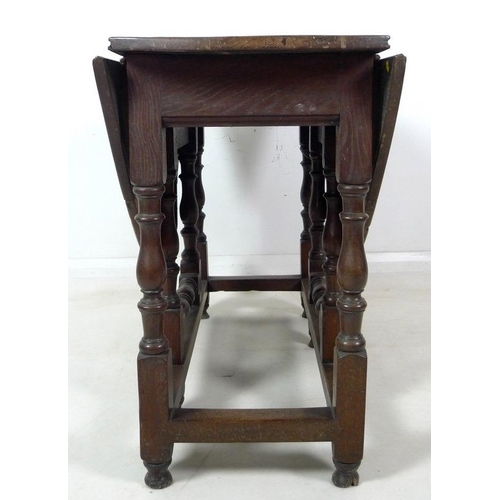 994 - An 18th century oak drop leaf table, oval surface, single drawer with brass knob, turned supports wi... 