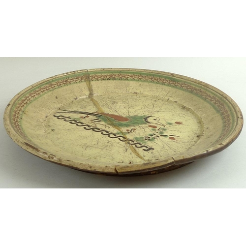 506 - An early pottery charger, possibly 16th/17th century, decorated in green and terracotta enamels with... 