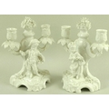 A pair of Meissen porcelain twin branch candlesticks, each moulded with a child in late 17th / early... 