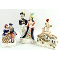 A collection of three Victorian Staffordshire flatbacks, one modelled as a lady and gentleman holdin... 