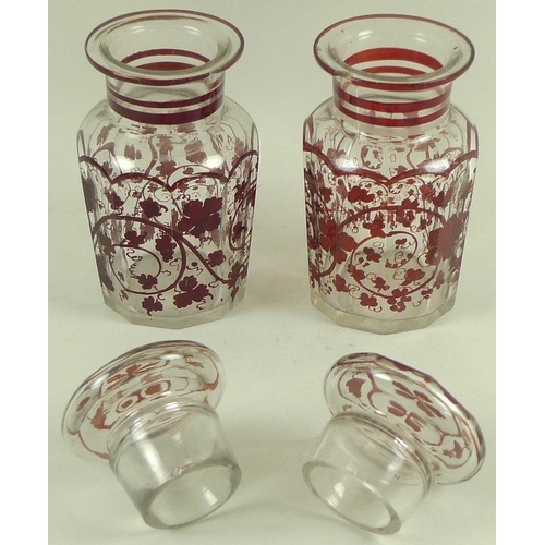 559 - A pair of Continental glass faceted jars and covers, late 19th century, decorated in dark red with s... 