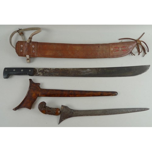 633 - An Indonesian Makassar Badik, together with a Malaysian Kris with intricately carved handle and unus... 