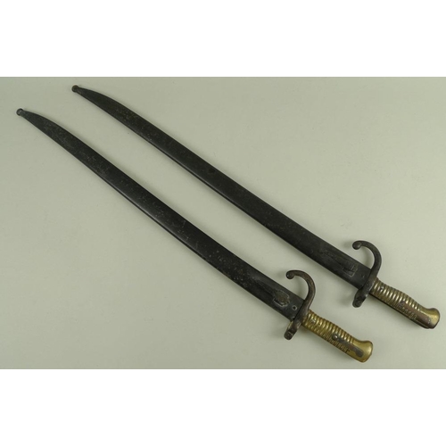 647 - Two French 19th century chassepot bayonets, with hooked quillions and ribbed brass handles, the spin... 