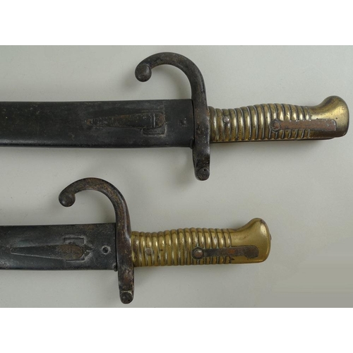 647 - Two French 19th century chassepot bayonets, with hooked quillions and ribbed brass handles, the spin... 