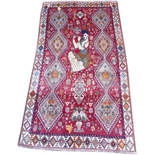 926 - A Shiraz rug with red ground, decorated with a lady playing a flute flanked by two rows of four conj... 