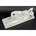 A mid 19th century reclining nude female figure, stretching upon a rumpled sheet above a stepped rec... 