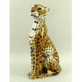 An Italian ceramic model of a seated cheetah, base incised Italy, possibly by Intrada, 24 by 48cm hi... 
