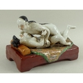 A modern Chinese erotic ceramic sculpture, depicting two lovers in the throes of passion, painted de... 