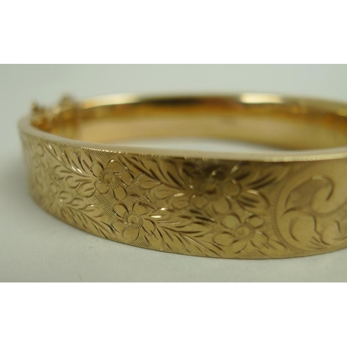 891 - A collection of gold items, comprising a 9ct gold bangle foliate engraved, complete with safety chai... 