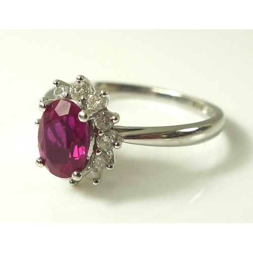 899 - A 9ct white gold, diamond and vibrant pink tourmaline ring, the central oval cut tourmaline of 7 by ... 